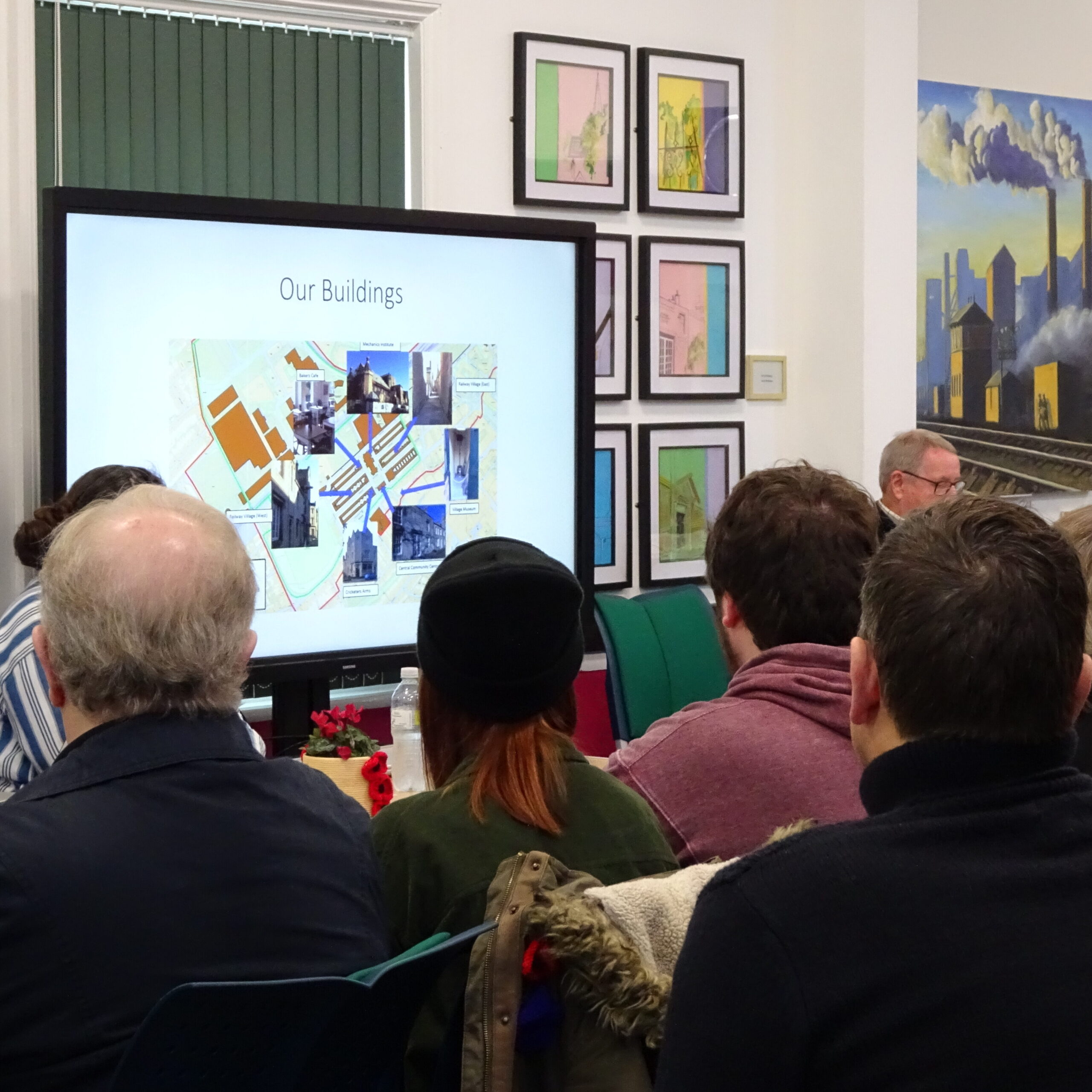 Audience looks towards the screen as David Thackray provides an overview of trust buildings in the Chair's report. Annual General Meeting 2023