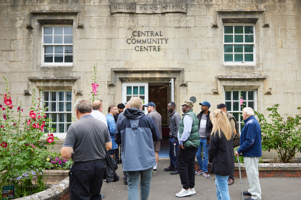 A group of people gathered outside the Central Community Centre in Emlyn Square