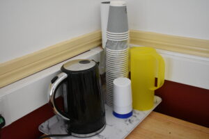 A picture of a kettle and cups for refreshments.