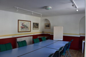 A rectangle chair layout with chairs and a flipchart in the Cricketers Lounge.