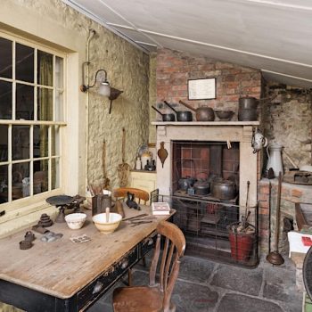 A Victorian Kitchen Extension with a table topped with utensils, a range and a mangle.